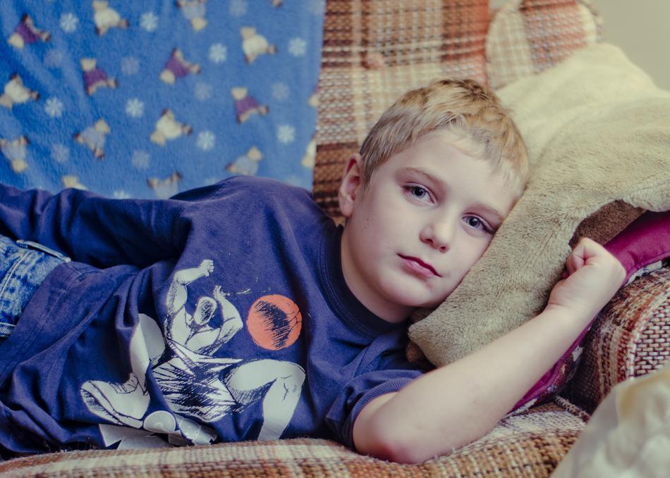 portrait of Boy Cranky Sad Laying on sofa