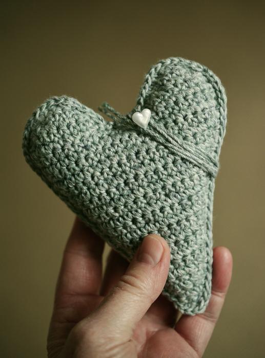 Beautiful, green, crocheted heart, in the hand