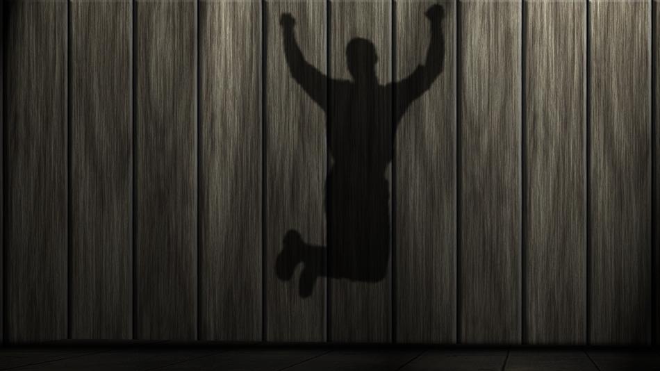 shadow of a jumping man on a wooden background