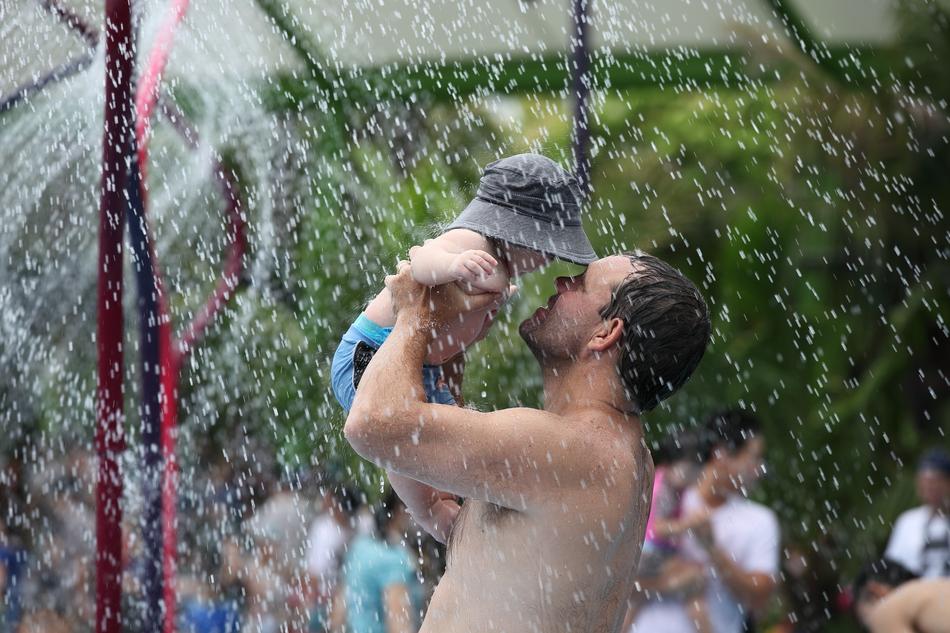 Father with son, under the shower, near the other people