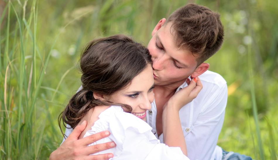 couple in love on green grass with blurred background