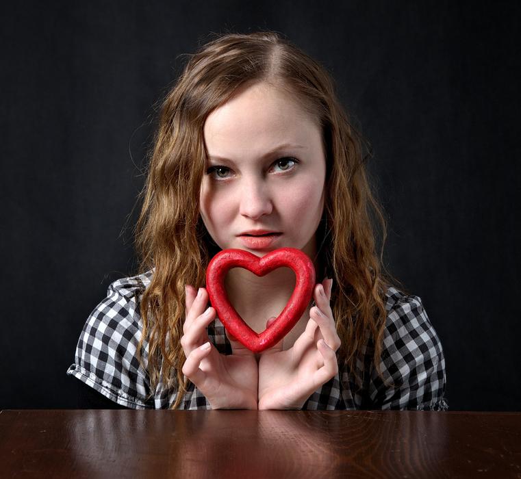 Portrait of the girl, with the beautiful, red heart, in light, among the darkness