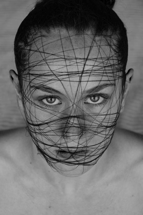 young girl face entangled with threads