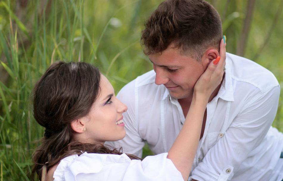 couple in love on green grass on blurred background