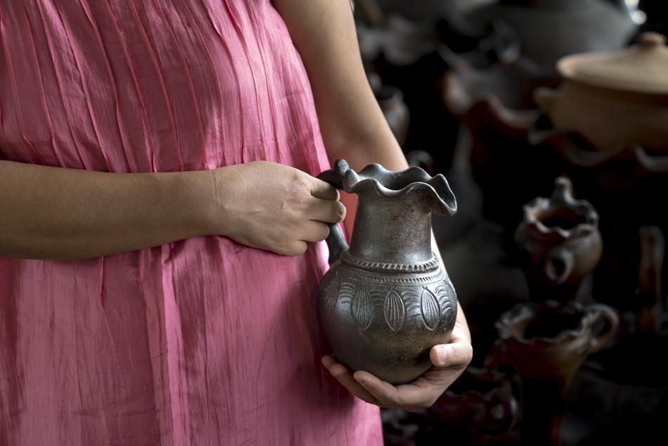 Woman, holding beautiful, patterned vase in the hands, in Asia