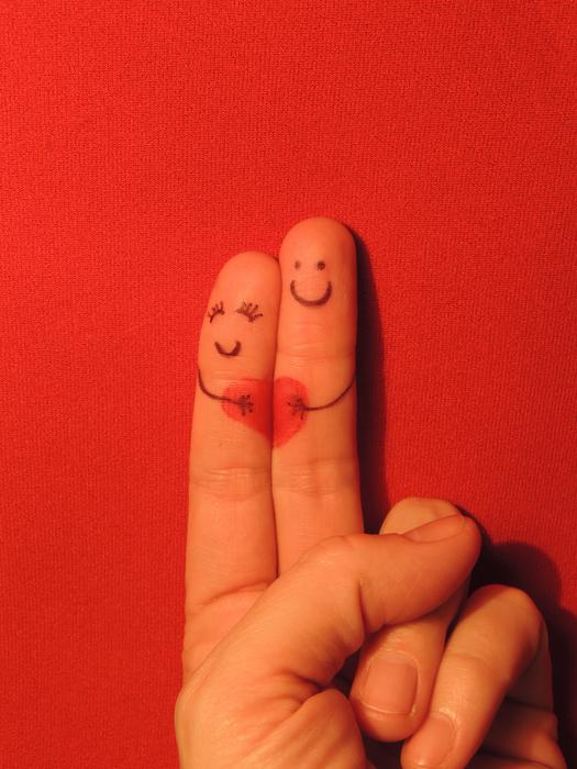 Fingers with drawings, in love, on the red surface, in light
