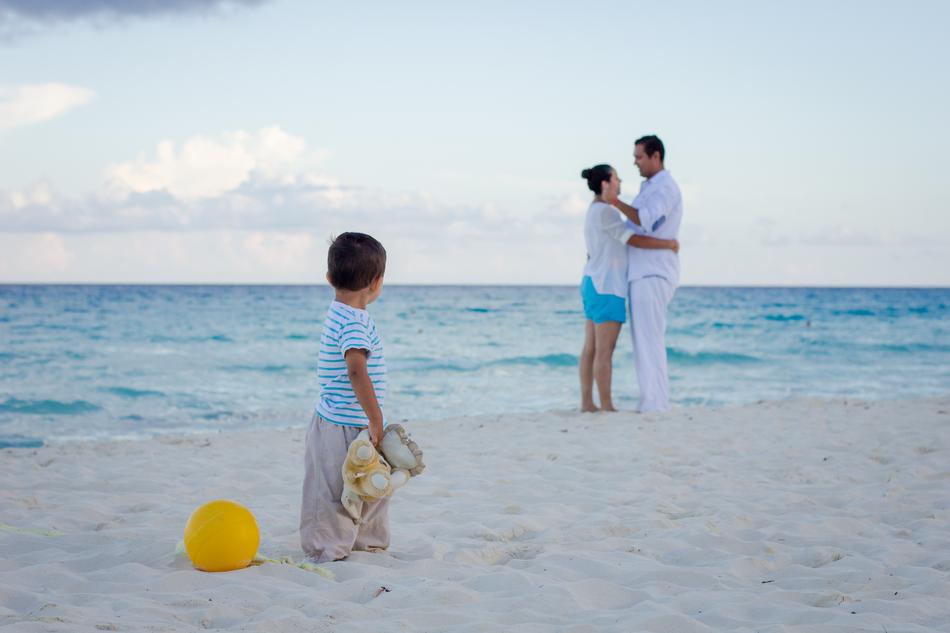 family resting on the beach by the sea