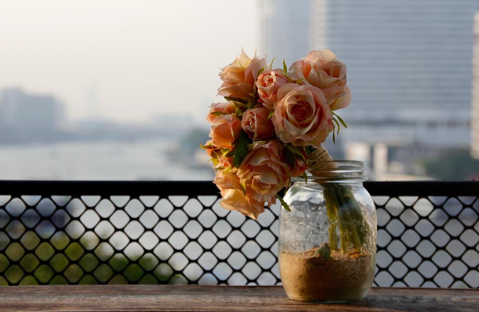 Dried Roses Bouquet in jar at blur city background