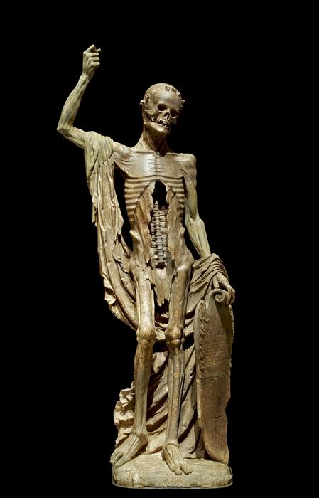 Shiny figure of skeleton with plate, at black background
