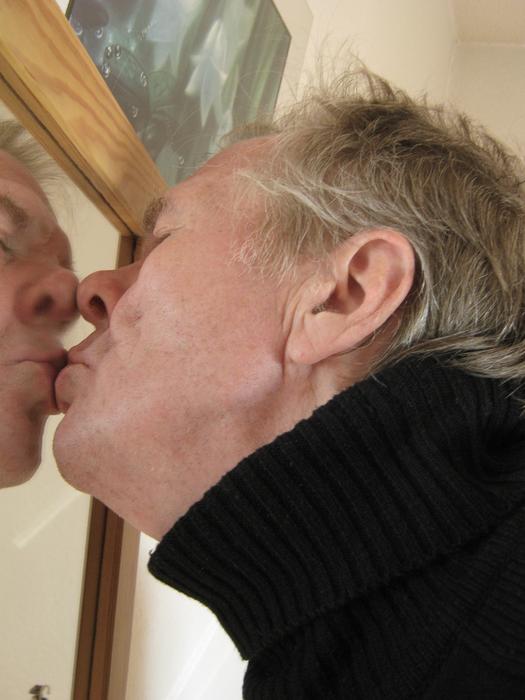 Man kissing himself in the mirror