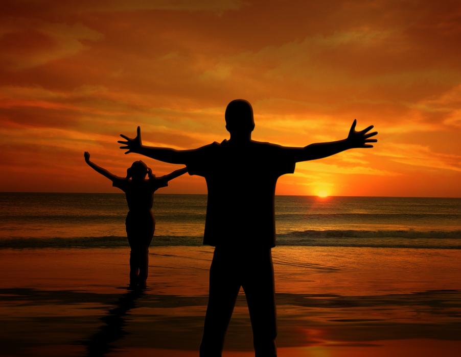 man and child girl on beach at sunset