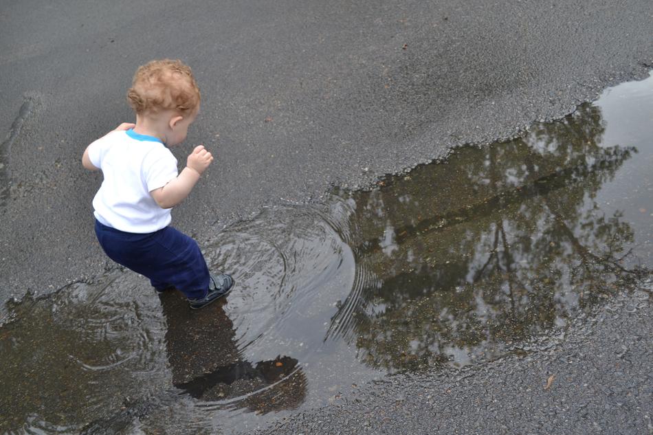 funny child boy playing in Puddle