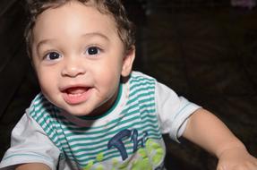 Portrait of the cute child boy in light, at dark background