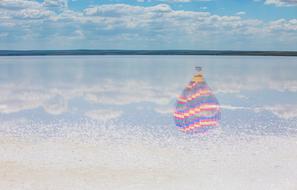 reflection of multicolored hot air balloon on the water surface