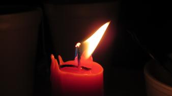 Close-up of the burning, colorful candle, at dark background