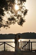 newlyweds on the lake at sunset