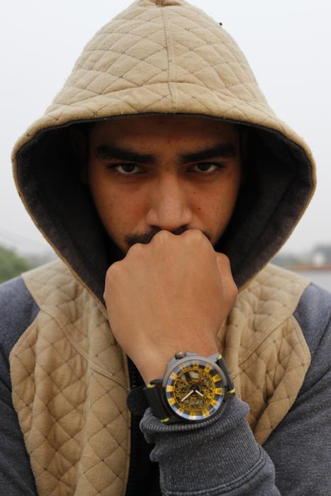 a man in a hood with a gold watch