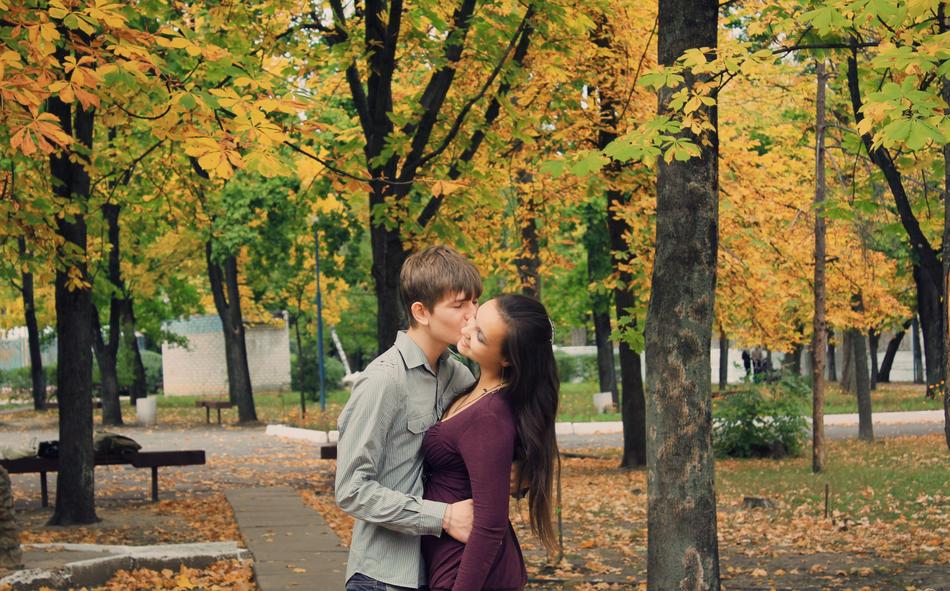 Sweethearts kissing among the colorful and beautiful park with plants