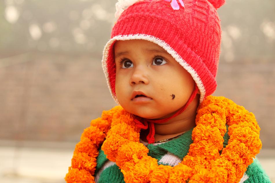Portrait of the cute child in red hat and with orange scarf