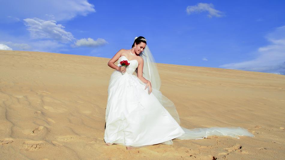 happy bride in white dress in the desert