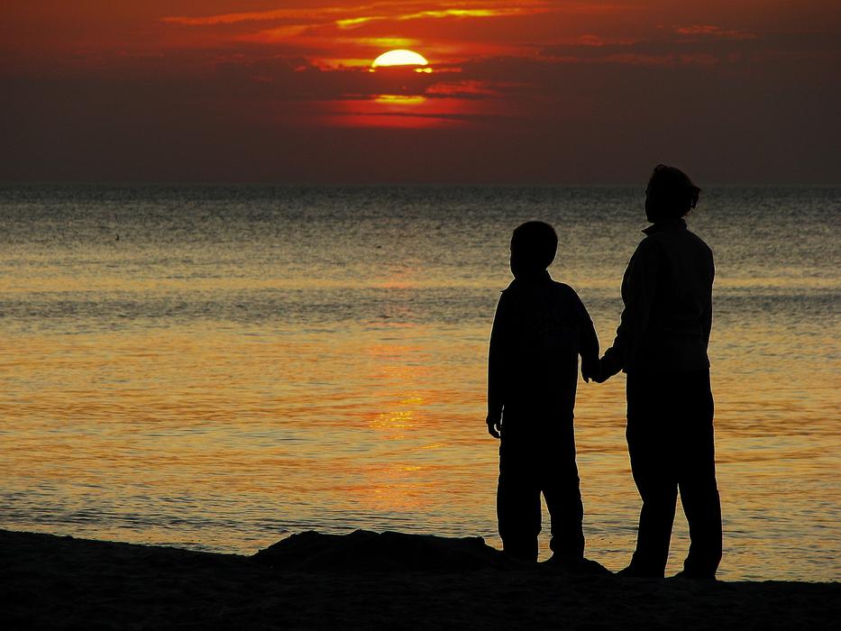 family on the shore of the Baltic Sea at sunset