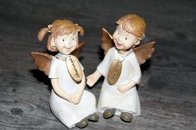 two little angels sitting on a table