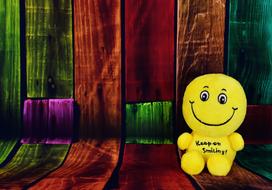 funny yellow toy near colored wall