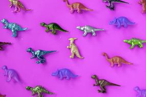 Small toy dinosaurs on a purple background