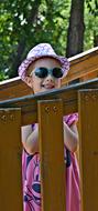 Happy Girl Child hide behind fence