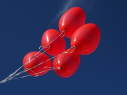 Five red balloons in the sky