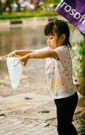 Asian girl collects raindrops in a bag