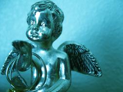 Iron statue of an angel on blue background