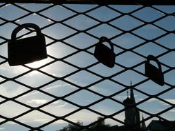 the silhouette of the locks on the fence