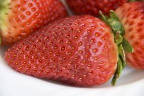 red strawberry with green leaves, close-up