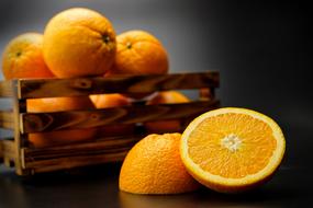 cut orange and ripe oranges in a box