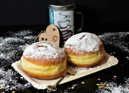 two donuts with sugar cake and a cup of coffee