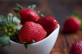 ripe strawberries in a white porcelain bowl