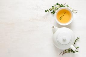 white teapot and cup of green tea