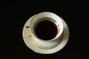 porcelain cup with drink on dark background