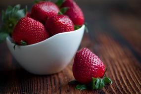 red ripe strawberries in a white bowl