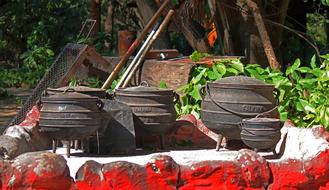 three iron cauldrons in nature on a sunny day