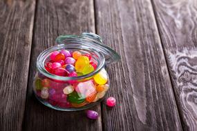multicolored candies in a transparent jar on the table