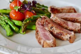 veal steak with asparagus and tomatoes