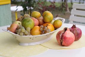 fruit in a bowl and pomegranates