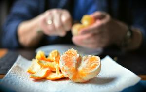 hands of person peeling Orange