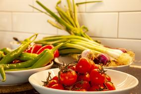 tomatoes, leeks and peppers on white plates