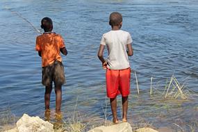 boys with fishing rods on the river