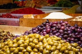 green and purple olives on the counter in the market