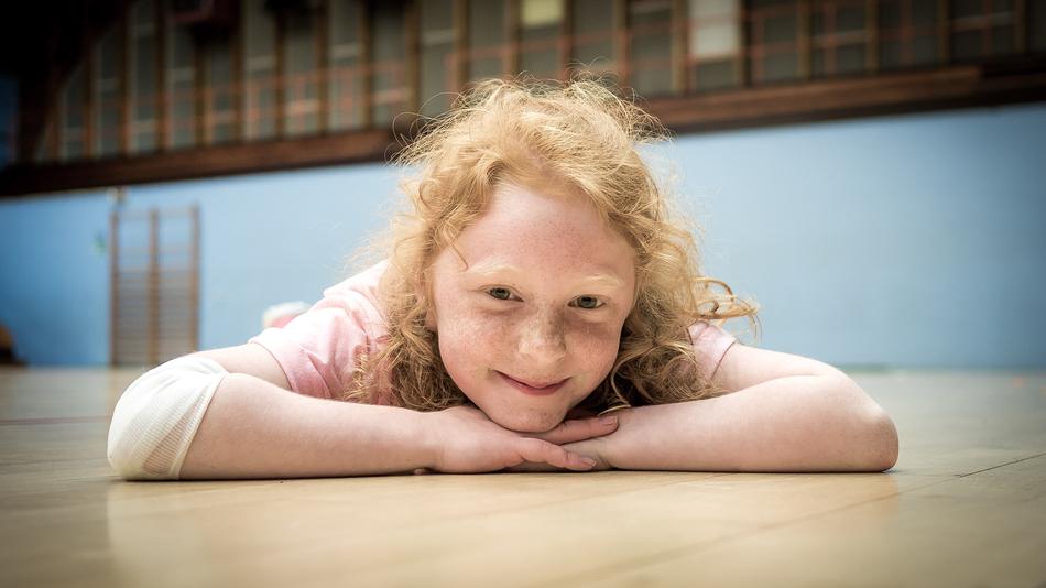Happy Little Girl Gymnast in Hall