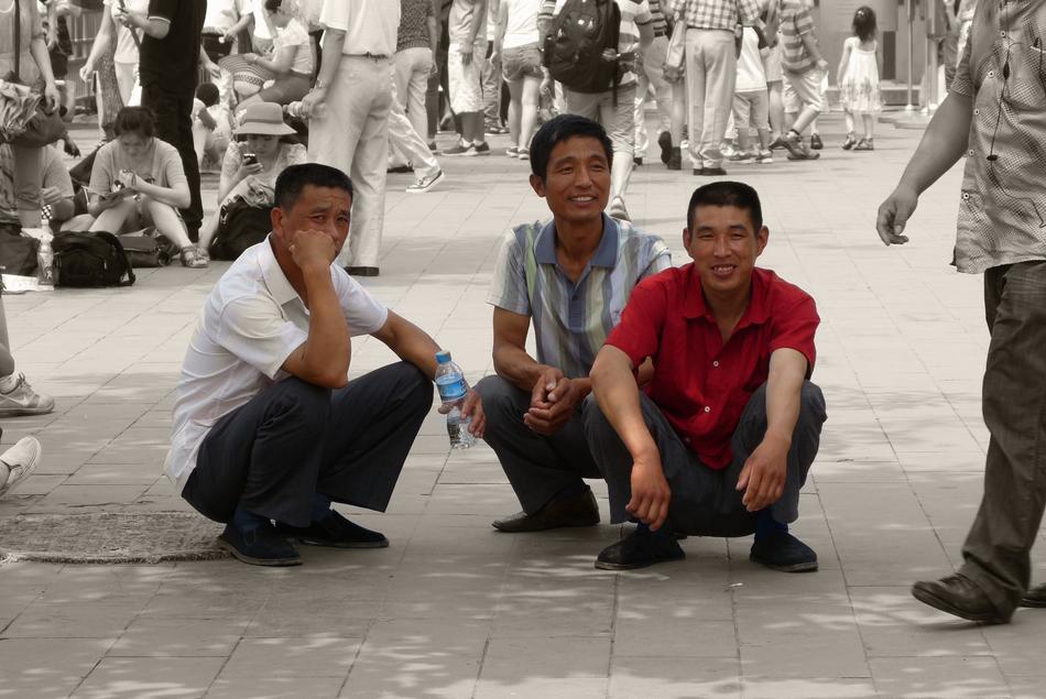 Three men are resting in the shade
